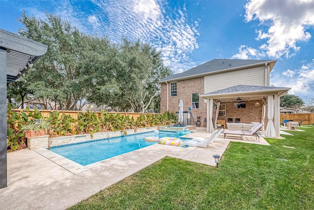 view of pool featuring a jacuzzi, a patio, ceiling fan, and a lawn