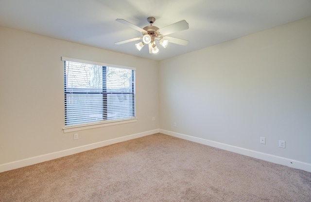 spare room featuring ceiling fan and light carpet