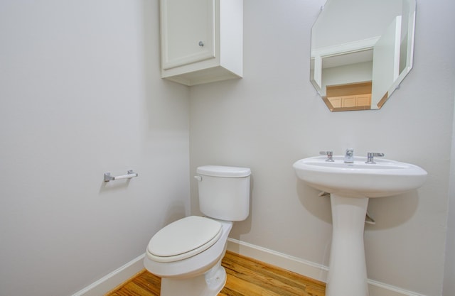 bathroom featuring hardwood / wood-style flooring and toilet