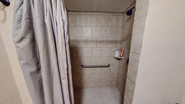 bathroom featuring a shower with curtain and a textured ceiling