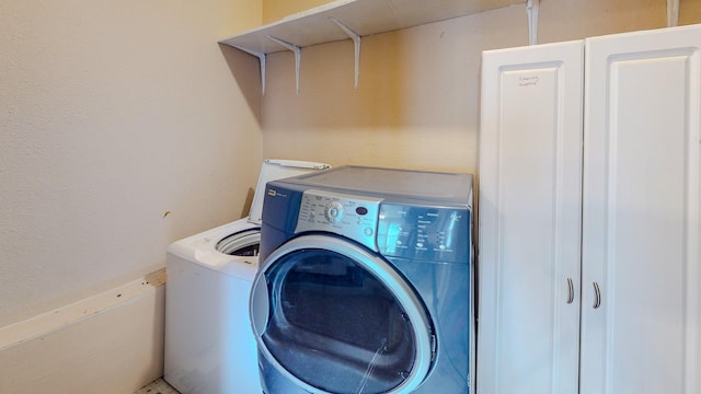 clothes washing area with washing machine and dryer