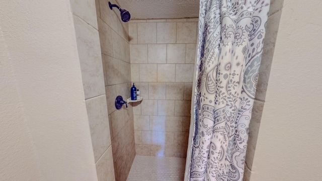 bathroom with a shower with shower curtain and a textured ceiling