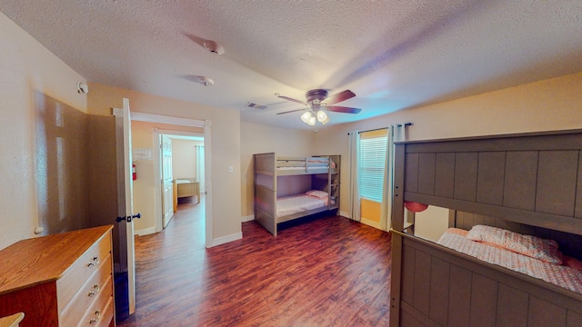 bedroom with ceiling fan, dark hardwood / wood-style flooring, and a textured ceiling