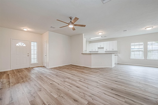 unfurnished living room featuring light hardwood / wood-style flooring, a wealth of natural light, and ceiling fan