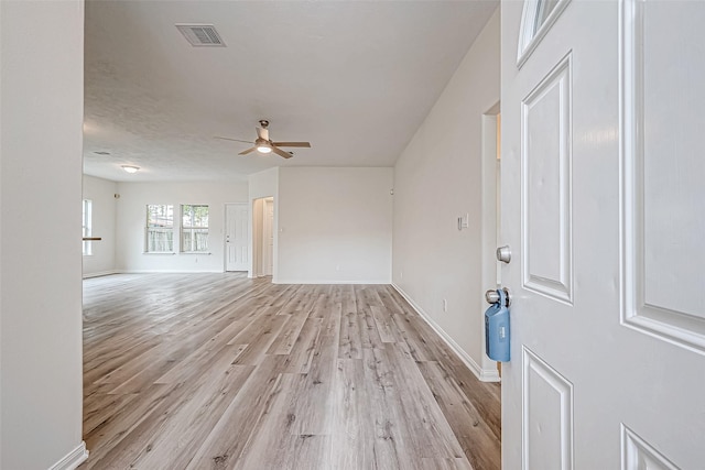 unfurnished living room featuring ceiling fan and light hardwood / wood-style floors