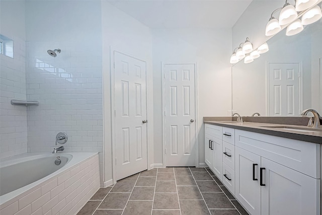 bathroom with tile patterned flooring, vanity, and tiled shower / bath