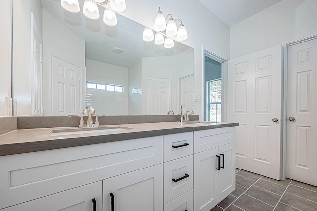 bathroom with tile patterned flooring, vanity, and an inviting chandelier