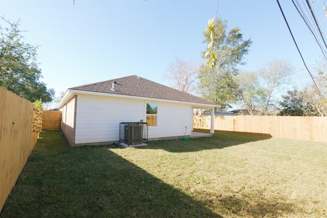 back of property with central air condition unit and a lawn