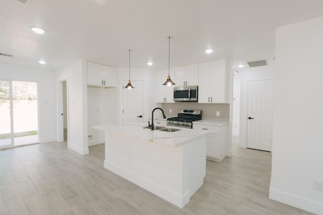 kitchen with white cabinets, sink, an island with sink, and appliances with stainless steel finishes