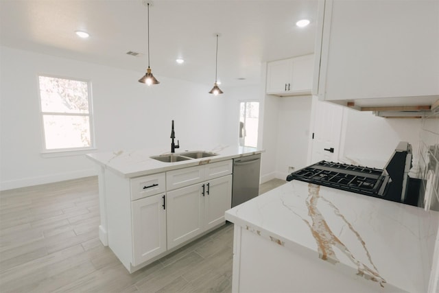 kitchen featuring white cabinets, dishwasher, light stone countertops, and an island with sink