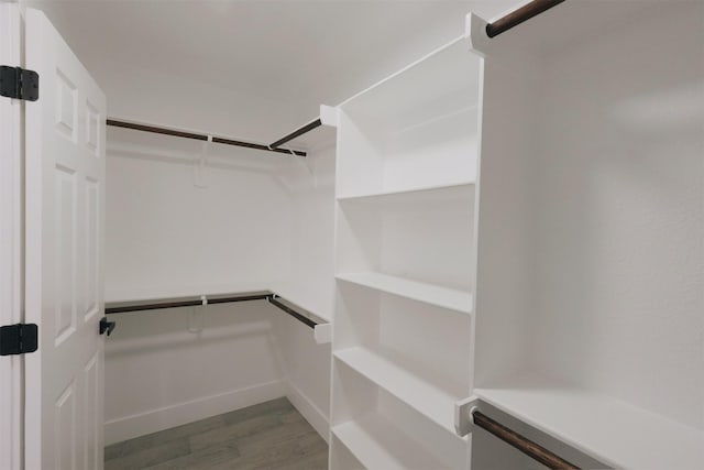 walk in closet with dark hardwood / wood-style flooring