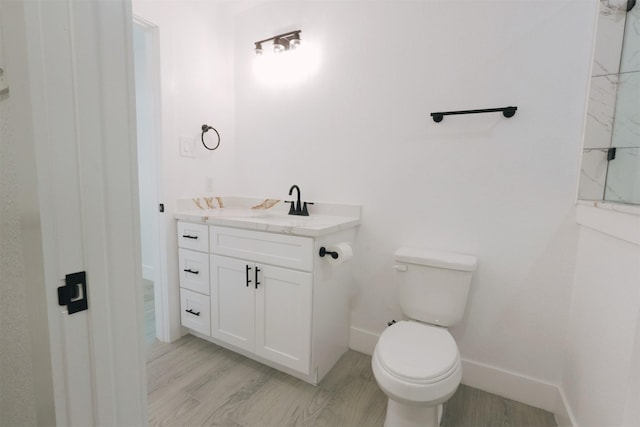 bathroom with vanity, wood-type flooring, and toilet