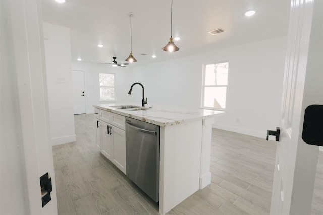 kitchen featuring light stone counters, stainless steel dishwasher, sink, a center island with sink, and white cabinetry