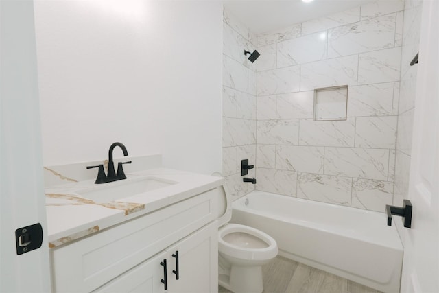 full bathroom with toilet, wood-type flooring, vanity, and tiled shower / bath combo