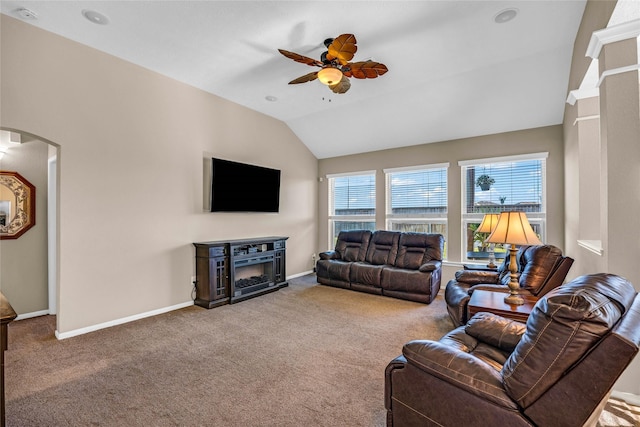 carpeted living room with a fireplace, ceiling fan, and lofted ceiling