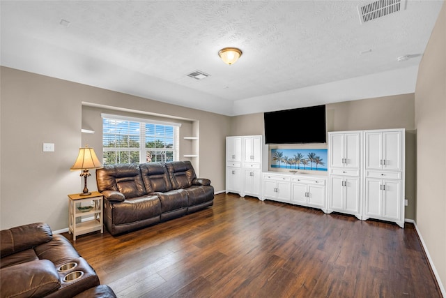 living room with built in shelves, a textured ceiling, and dark hardwood / wood-style floors