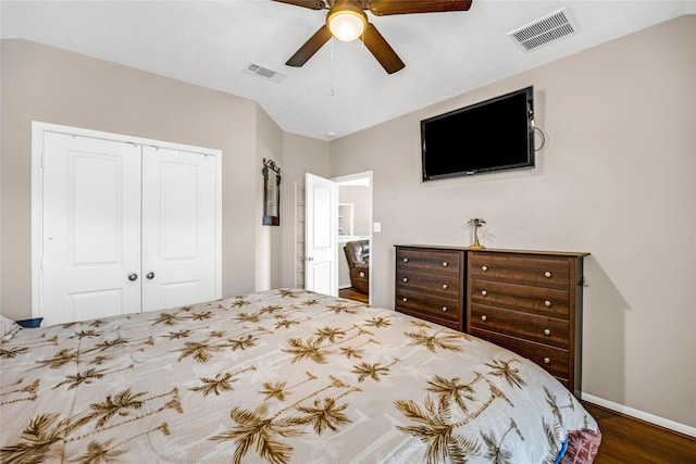 bedroom with ceiling fan, dark wood-type flooring, and a closet