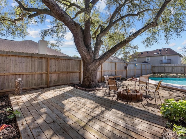 deck with an outdoor fire pit and a covered pool