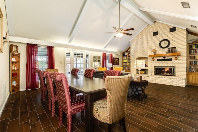 dining area featuring vaulted ceiling with beams, ceiling fan, and a fireplace