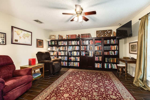 sitting room with ceiling fan and a textured ceiling