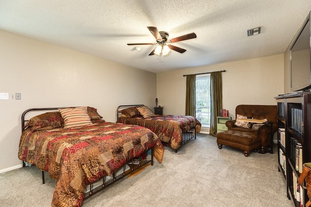 bedroom with a textured ceiling, light colored carpet, and ceiling fan