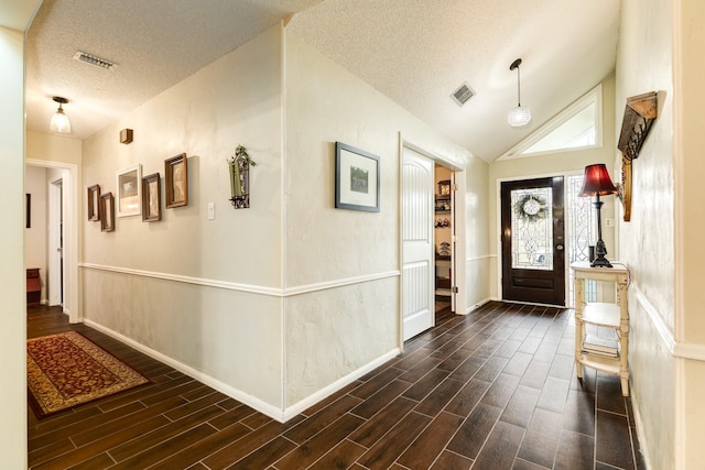 foyer featuring lofted ceiling and a textured ceiling