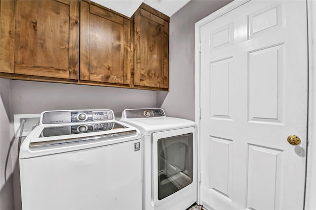 laundry area with cabinets and washing machine and clothes dryer