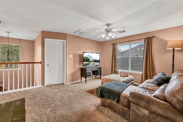 living room with carpet flooring, a wealth of natural light, ceiling fan, and a textured ceiling