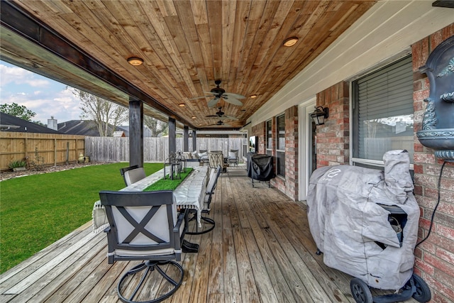 deck with ceiling fan, a yard, and grilling area