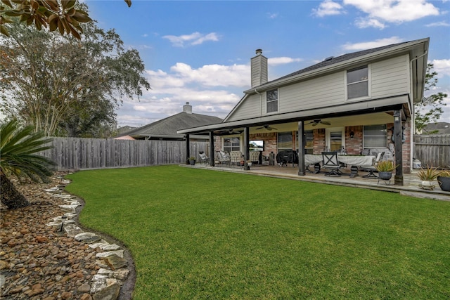 rear view of house with a patio area, ceiling fan, a yard, and an outdoor living space