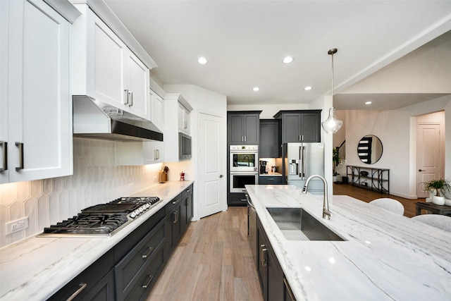 kitchen featuring decorative backsplash, appliances with stainless steel finishes, sink, decorative light fixtures, and white cabinets