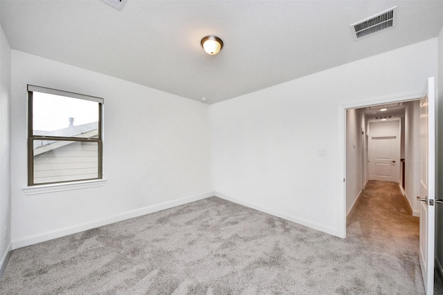 spare room featuring light colored carpet