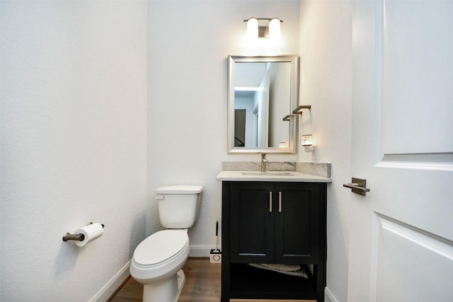 bathroom with hardwood / wood-style floors, vanity, and toilet