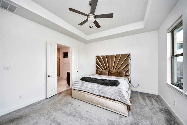 bedroom featuring a tray ceiling, ceiling fan, and carpet