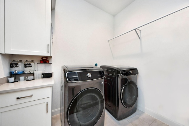 washroom with cabinets, independent washer and dryer, and light tile patterned floors