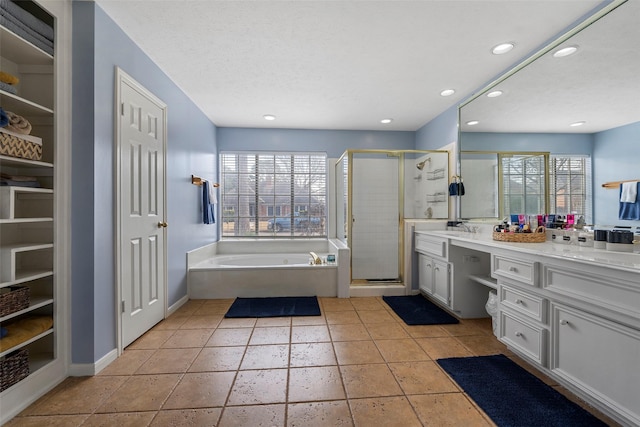 bathroom featuring vanity, separate shower and tub, and a textured ceiling