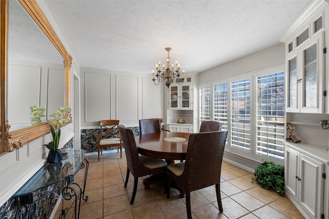 dining room with a textured ceiling and a notable chandelier