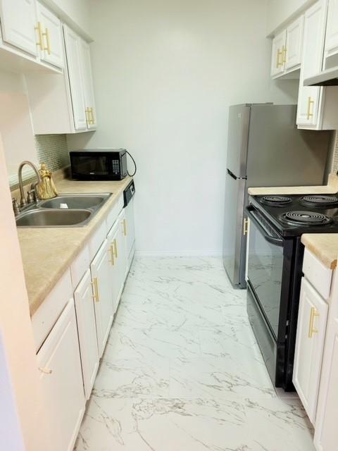 kitchen with white cabinetry, sink, and black appliances