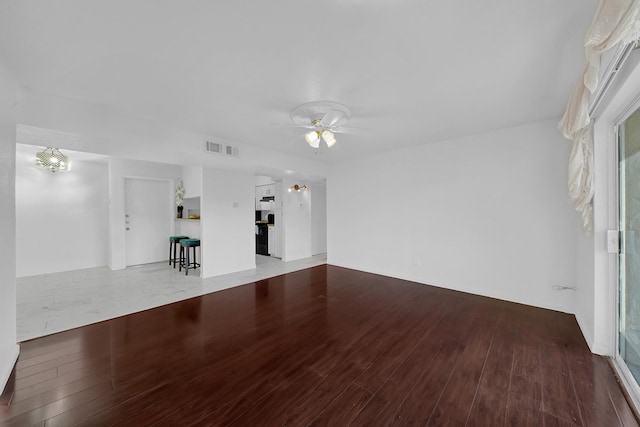 unfurnished living room with hardwood / wood-style floors and ceiling fan with notable chandelier