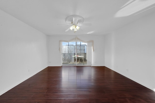 unfurnished room with ceiling fan and dark wood-type flooring