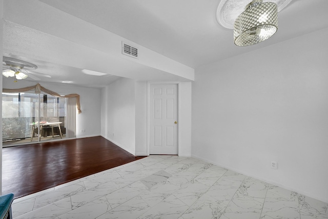 interior space featuring ceiling fan with notable chandelier