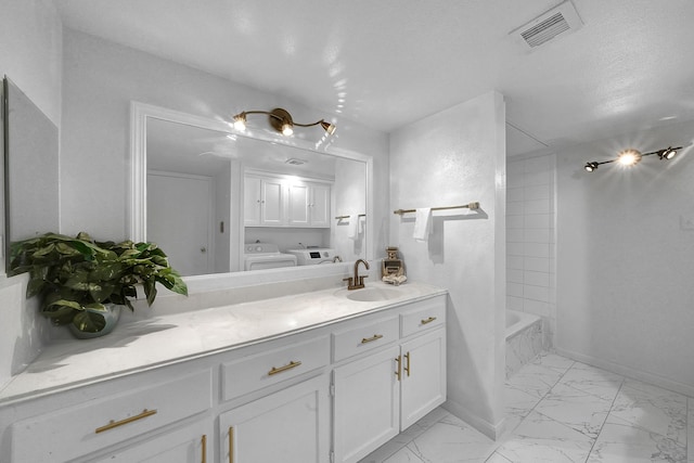 bathroom featuring bathtub / shower combination, a textured ceiling, vanity, and separate washer and dryer