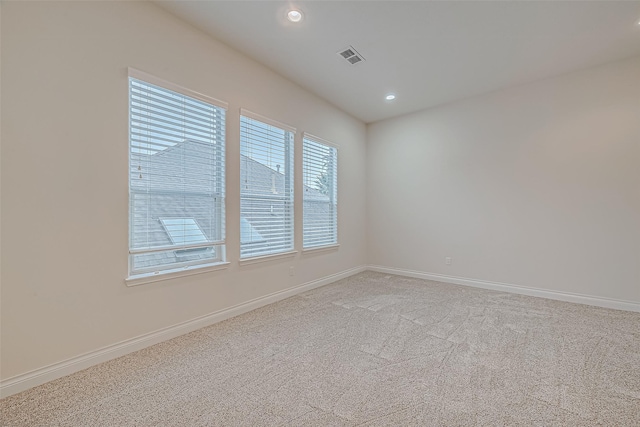 carpeted spare room featuring a wealth of natural light