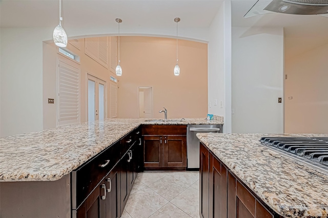 kitchen with light stone countertops, sink, pendant lighting, dishwasher, and light tile patterned flooring