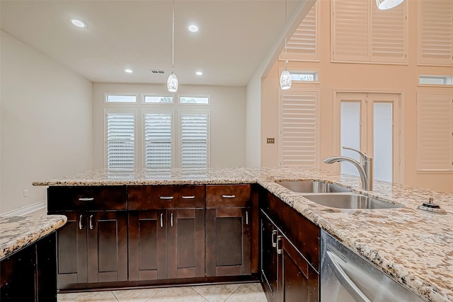 kitchen with sink, stainless steel dishwasher, light stone countertops, light tile patterned floors, and decorative light fixtures