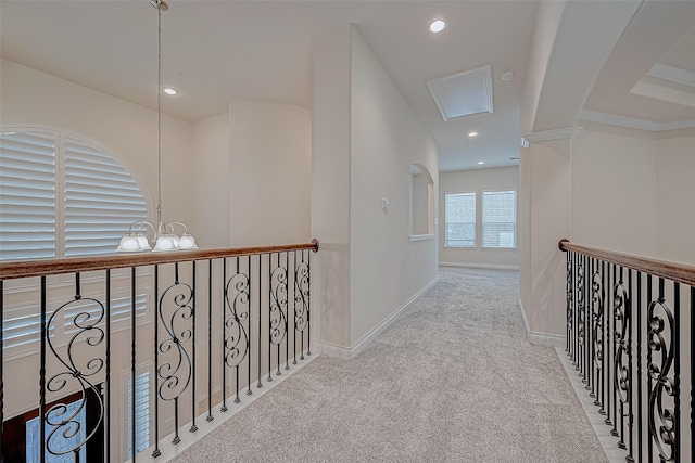 corridor featuring light colored carpet and a chandelier