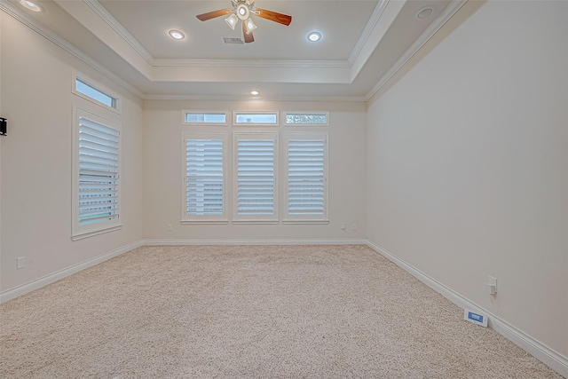 unfurnished room with a raised ceiling, ceiling fan, and carpet floors