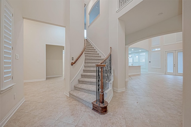 tiled foyer entrance with french doors and a high ceiling