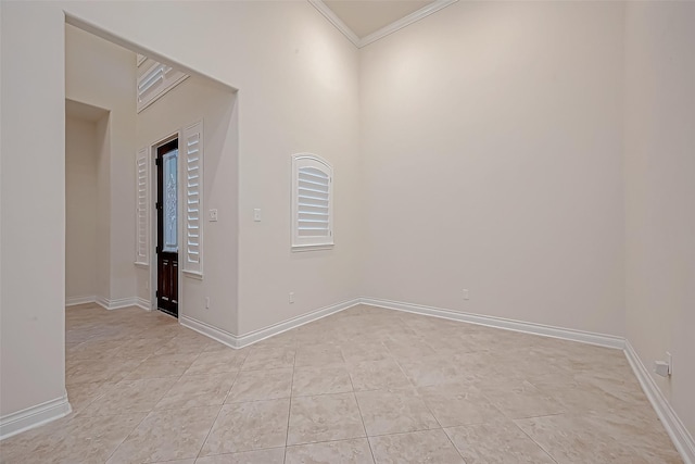 spare room featuring light tile patterned flooring and crown molding