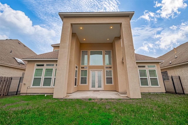 back of property with a lawn, a patio area, and french doors